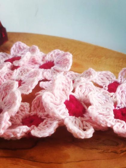 A scattering of delicate pink crochet flowers. These can be used in so many ways, from hair accessories to home decor, adding a touch of handmade charm.