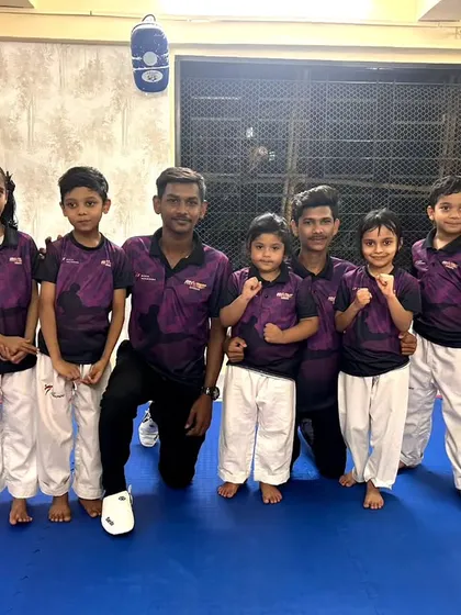 Our team, united and strong. Coaches and students pose together in our academy's official t-shirts, representing the Fit and Fight family.