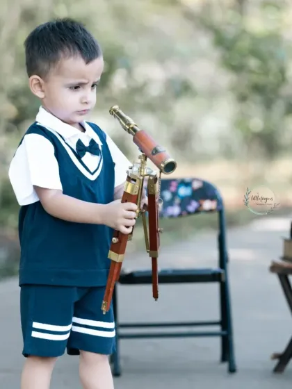 A young astronomer studying his telescope. I love providing unique props that spark a child's imagination and lead to wonderfully candid and thoughtful photographs.
