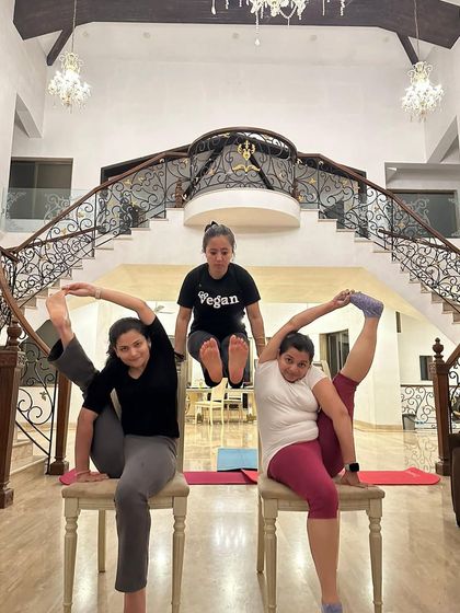 Time for some impromptu acro at a retreat. This fun group pose combines chair poses and an L-sit, showing the creative side of yoga.