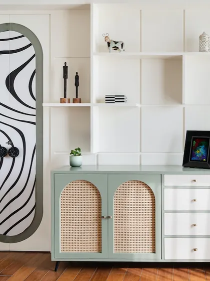 This corner of the "Crimson Paradise" home showcases our love for custom furniture. A mint green console with cane doors is paired with a bold, hand-painted door, creating a quirky and artistic statement.