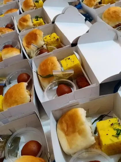 A look inside our snack boxes prepared for an Independence Day event. Each box contains a mix of savory and sweet items like dhokla, vada pav, and gulab jamun, perfect for society gatherings.