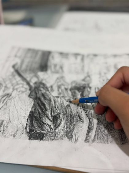 The foundation of a strong portfolio is mastering the fundamentals. Here, a student works on a detailed pencil sketch, focusing on shading, texture, and form. This dedication to technical skill is essential for bringing complex ideas to life.