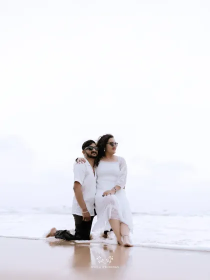A serene portrait of the couple on the beach, with the waves gently washing ashore.