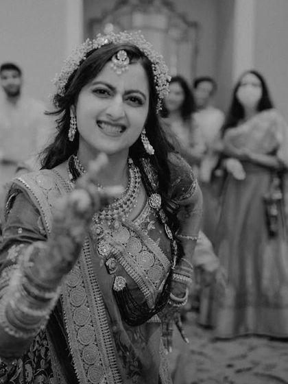 The bride, in the middle of her Mehendi party, dancing with pure joy. This black and white candid shot captures the vibrant energy and celebratory mood of the event.
