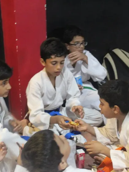 After the test, it's time to celebrate the achievement. Students share snacks and celebrate their new belts together, reinforcing our family-like community.