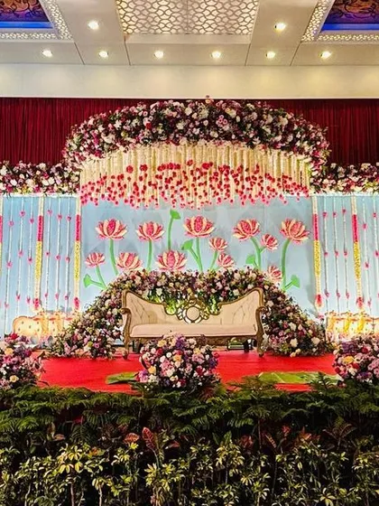 A breathtaking stage for a twin babies' cradle ceremony, designed with symmetrical floral moons and a vibrant lotus theme. This grand setup combines traditional motifs with a lavish floral display, creating a truly memorable backdrop for a special day.