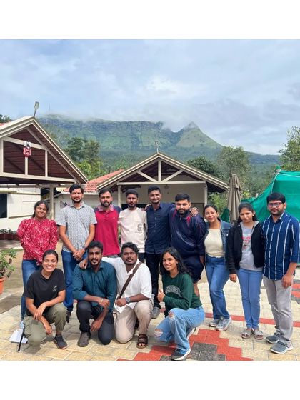 A group photo outside our charming homestay in Chikmagalur, with the mountains looming in the background. This is our home for the weekend.