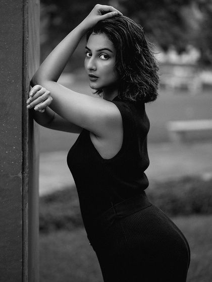 This black and white version of an outdoor portrait emphasizes form and emotion. Without color, the focus shifts to the model's pose, expression, and the elegant lines of her dress.