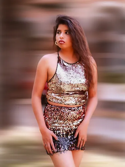 A stylish and confident portrait with a blurred background that emphasizes the subject. The sequin outfit adds a touch of party-ready glamour.