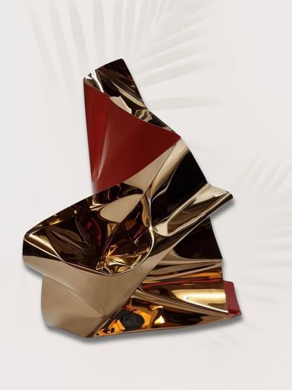 The elegant twist of this red and gold table sculpture, a small piece that carries a lot of visual impact.