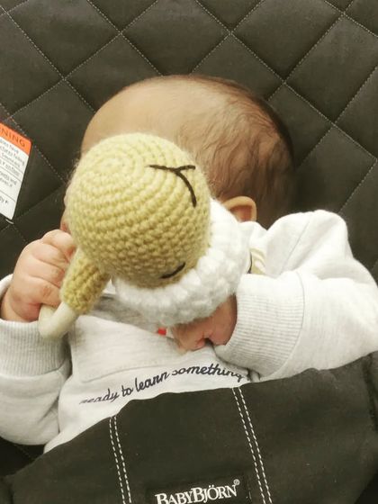 A precious moment of a baby enjoying the handmade sheep rattle. It's designed to be easy for tiny hands to hold and explore.