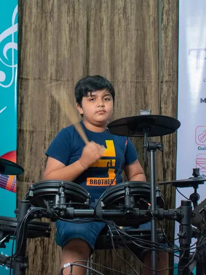 A young student behind the drum kit at our HSR open mic session.