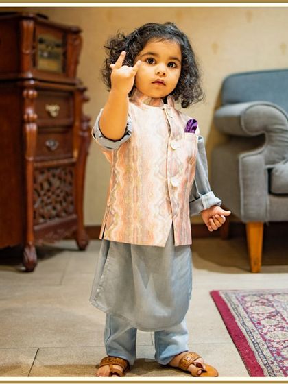 This little rockstar is ready for the festivities in his printed Bundi set. The cool grey kurta and unique jacket print create a stylish and modern ethnic look.