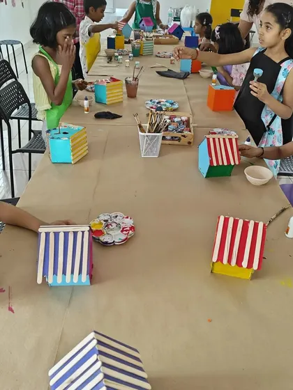 The party table is a hub of activity as kids add colorful roofs and details to their DIY birdhouses.