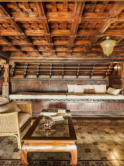 The intricate woodwork and traditional seating arrangement in one of our common areas. This space reflects the rich craftsmanship of Kerala, offering a beautiful and authentic environment for our guests.