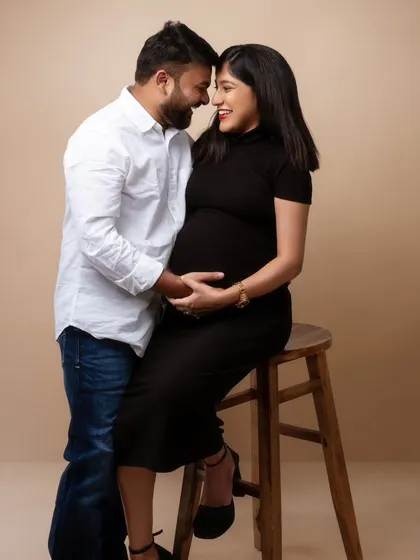 A moment of pure connection, forehead to forehead. This simple, elegant pose speaks volumes about their partnership and shared anticipation. The clean background ensures their bond is the central story.