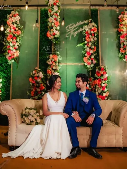 Modern, chic, and all about you. This reception stage combines a lush floral wall with a custom neon sign, creating a perfect backdrop for the couple. We design spaces that reflect your personal style.