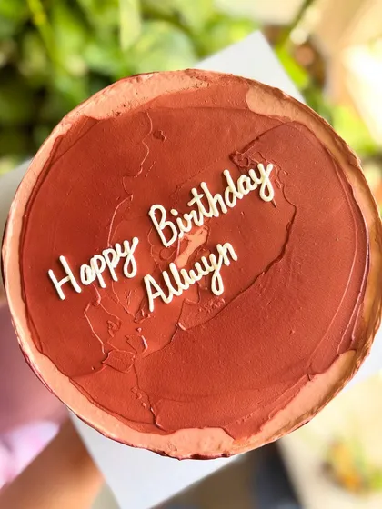 An overhead shot of the textured brown birthday cake, showing the rustic yet chic finish of the buttercream.