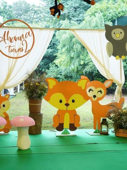 The photo booth for our Boho Chic animal party featured adorable woodland creature cutouts, like a fox and a deer, set against a simple draped backdrop. The soft pink mushroom props add a touch of whimsy.