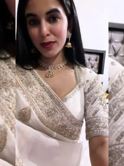 A client selfie showing her hand-embroidered organza saree and matching blouse. The V-neck blouse features the same intricate silver embroidery as the saree border.
