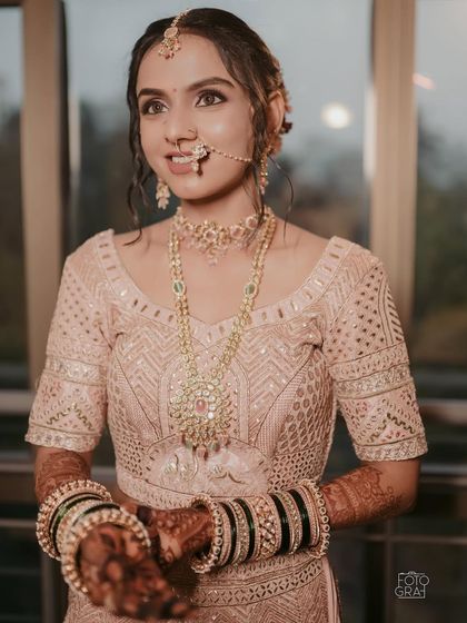 A portrait of the bride, highlighting the delicate jewelry and the soft, glowing makeup that enhances her features.