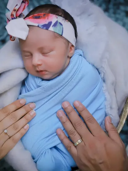 Parents' hands gently resting on their swaddled newborn. This shot symbolizes the love and protection surrounding your new baby.