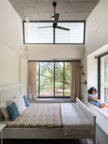 The daughter's bedroom, designed with high ceilings and large windows to feel spacious and connected to the outdoors. A wide window sill doubles as a reading nook, a perfect spot to get lost in a book.