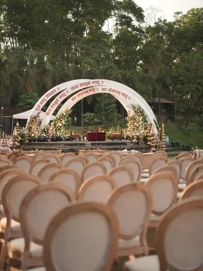 The view that greeted the guests at the 'Mantram' wedding. The clean lines of the chairs lead the eye directly to the magnificent mandap, set against a backdrop of lush greenery. Every element was planned for maximum impact.