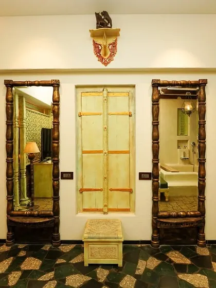 The entryway of the vintage suite, showcasing ornate carved wooden mirrors and doors that establish the room's unique, traditional aesthetic from the moment of entry.