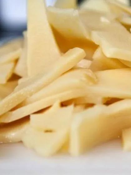 A close-up of the thinly sliced bamboo shoots, ready to be mixed with spices. This pickle has a distinct sour taste that is very popular.