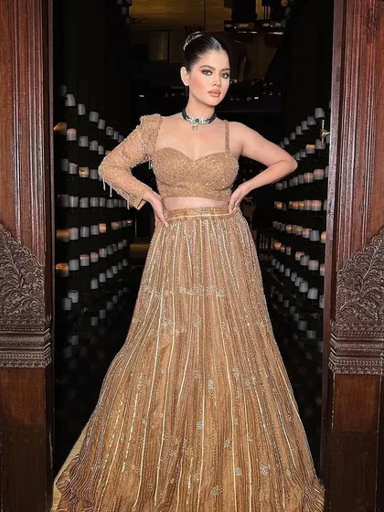 A stunning golden lehenga with a modern twist. I styled this with a one-shoulder blouse and a sleek high bun for a chic and contemporary look.