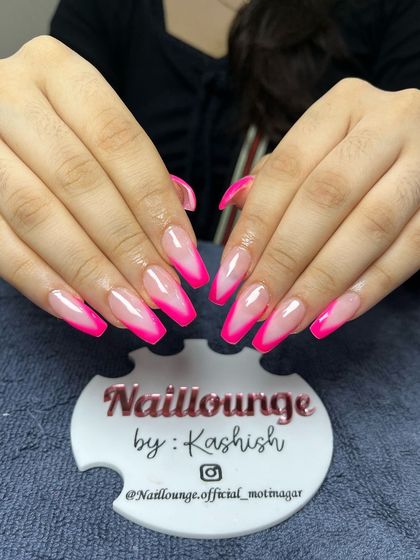 A vibrant neon pink French tip on long coffin nails for a bold and summery look.