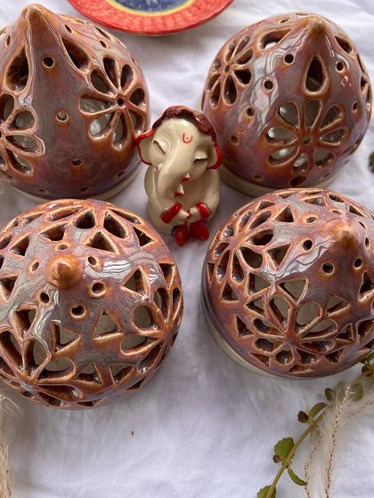 A collection of my festive tea light and dhoop holders, each with its own unique design and color.