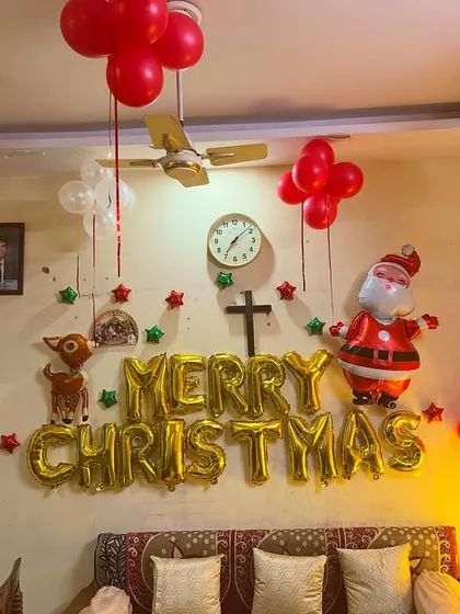 A 'Merry Christmas' foil balloon setup for a cozy living room celebration.