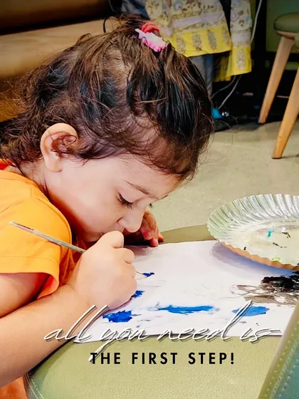 "All you need is the first step." A very young artist completely absorbed in her painting. It proves that creativity has no age.