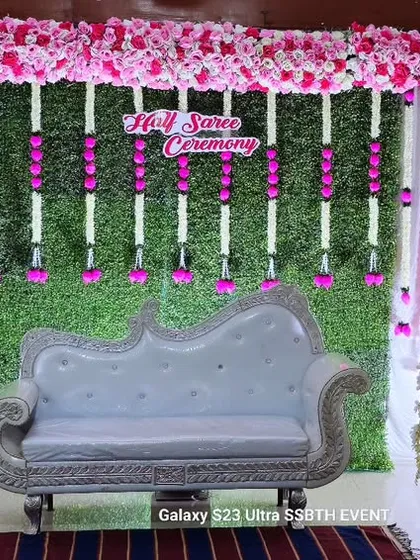 I created this elegant stage for a Half Saree Ceremony using a lush green wall backdrop. To complete the look, I added hanging floral garlands, a classic white diwan sofa, and decorative bird cages on pedestals, creating a perfect photo spot.