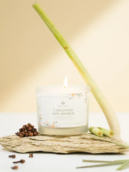 A lemongrass and clove scented candle styled with its raw ingredients. This natural, minimalist setup is perfect for brands that emphasize organic and natural products.