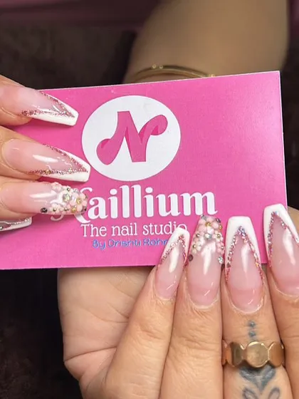 A close-up of these stunning V-cut French tip bridal nails. The combination of a sharp white tip and delicate glitter is perfect for a modern bride. I love holding up my business card to show off a fresh set.