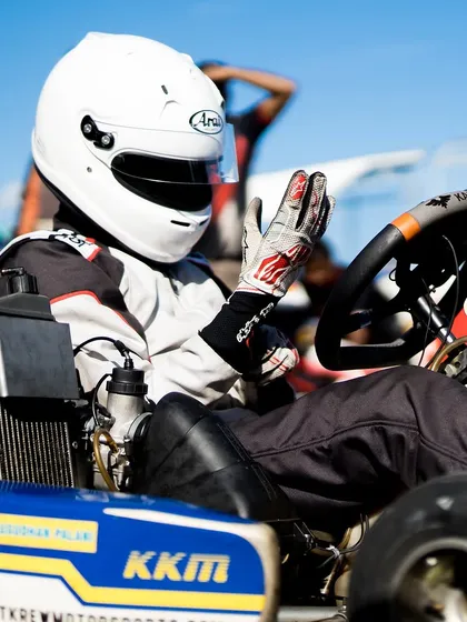 A driver in his kart, acknowledging the team.
