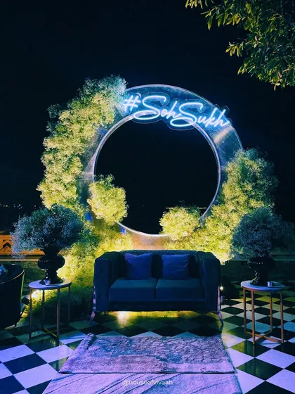 A modern and personalized photo-op. This circular installation, framed with greenery and a custom neon hashtag, provides a chic and interactive spot for guests to capture memories.