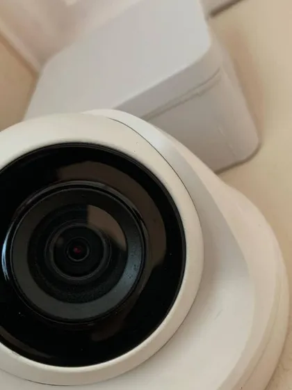 A close-up view of a smart indoor camera lens. These compact cameras are powerful, offering wide viewing angles and clear HD resolution to capture every detail.