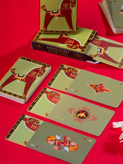 A colorful display of Namostutay playing cards with a horse motif. The bold red and green color scheme is energetic and eye-catching.
