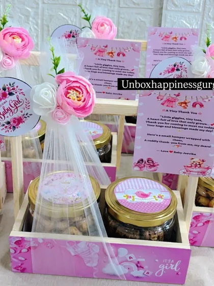 Another angle of the pink announcement favors, showcasing the personalized thank you cards and floral arrangements.