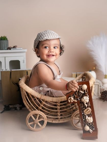 This little handsome boy of ours in his cart. The neutral tones and the "A" monogram add a personalized and classic touch to this milestone portrait.