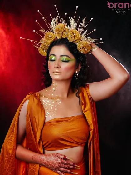 A golden goddess look, featuring a magnificent sun-ray headpiece and metallic gold makeup.