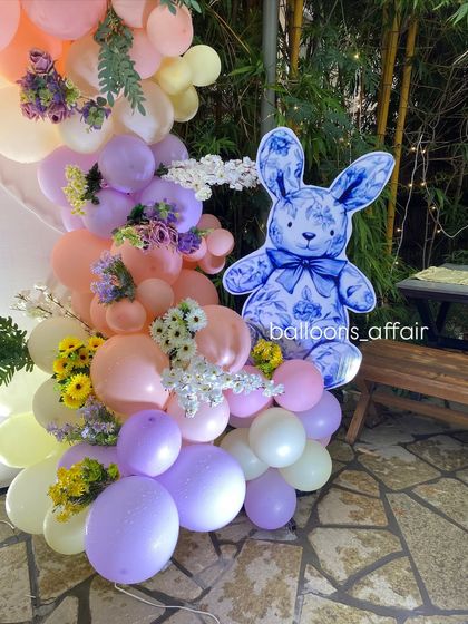 A detailed shot of the pastel balloon garland from the 'Oh Babies' shower, adorned with fresh flowers and a cute bunny cutout.
