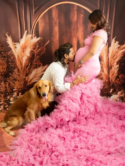 A glamorous maternity portrait featuring a flowing pink gown. I welcome partners and beloved pets to be part of the session, as they are an important part of your growing family's story. This shot captures the anticipation and love surrounding the new arrival.