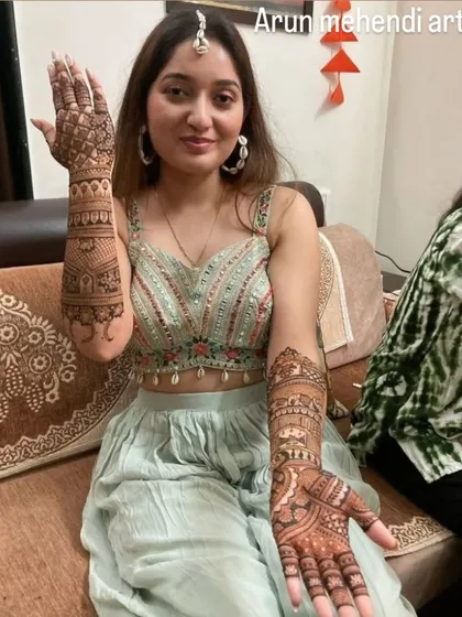A client showing off her beautiful sangeet mehendi. The design is intricate and covers the full arm, perfect for a celebration.