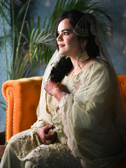 A radiant bride captured in a moment of quiet contemplation. The warm light from the window illuminates her features, creating a soft and beautiful portrait.